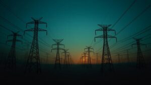 Transmission towers at dusk illustrating CIP-015 and BOD 26-02 internal network monitoring for electric utilities