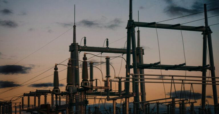 Satellite cellular backup for utilities: an electrical substation silhouetted against a dusk sky