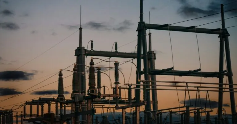 Satellite cellular backup for utilities: an electrical substation silhouetted against a dusk sky